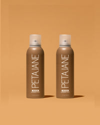 Two bottles of Peta Jane tanning mist on a brown background