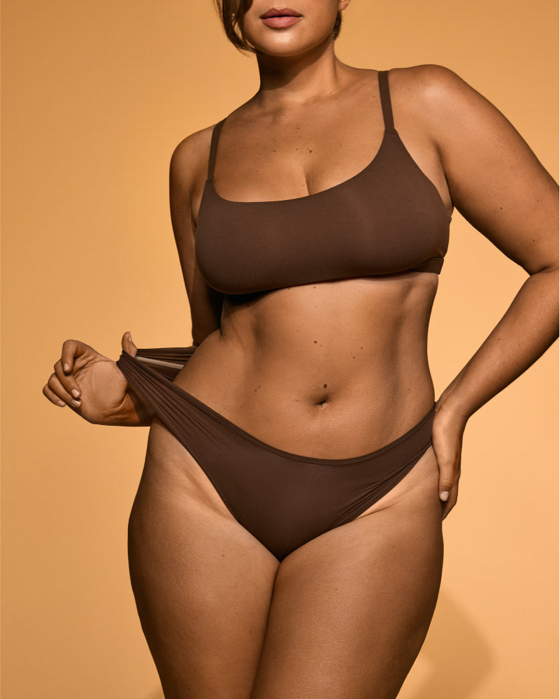 Model showcasing a smooth, deep bronzed tan on her torso and legs after using Peta Jane tanning products.