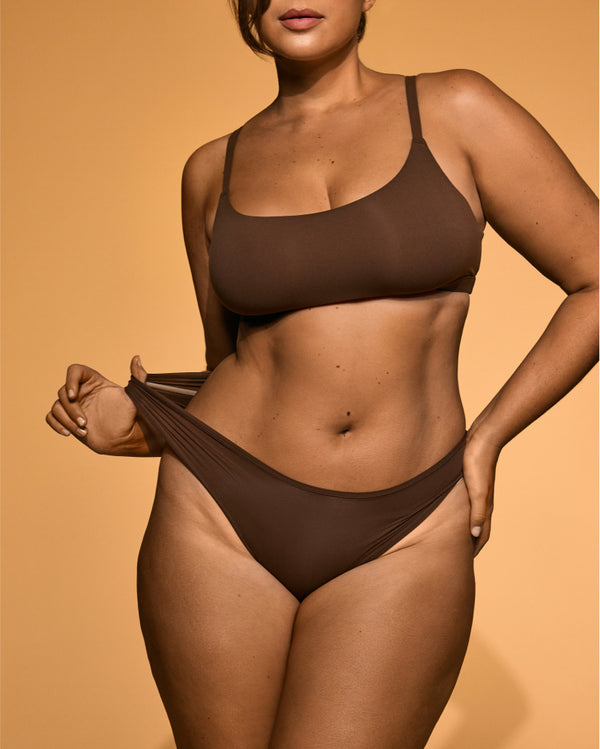 Model showcasing a smooth, deep bronzed tan on her torso and legs after using Peta Jane tanning products.