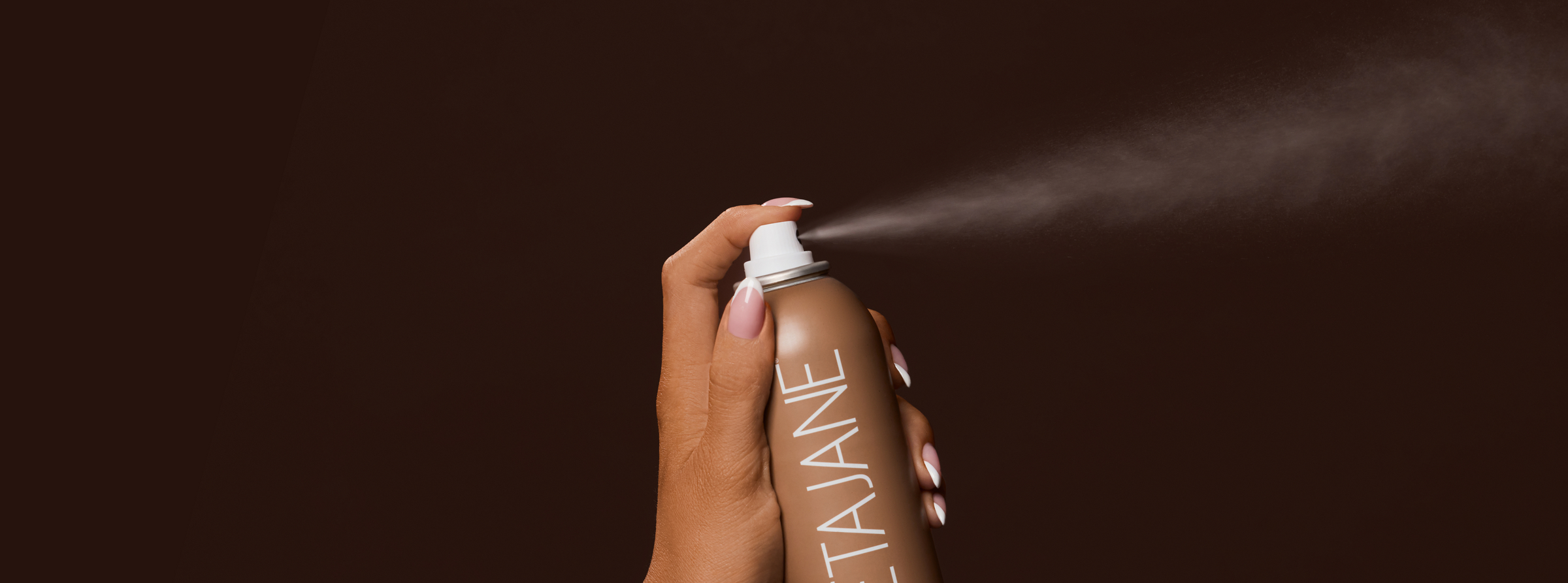 Applying Peta Jane Medium Tanning Mist for a flawless, professional sunless bronze glow.